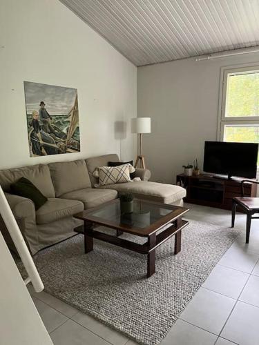 a living room with a couch and a coffee table at Tyylikäs koko perheen huoneisto in Vuokatti