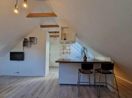 a kitchen with a counter and stools in a attic at Guesthouse on the footstep of Mount Ulriken in Bergen