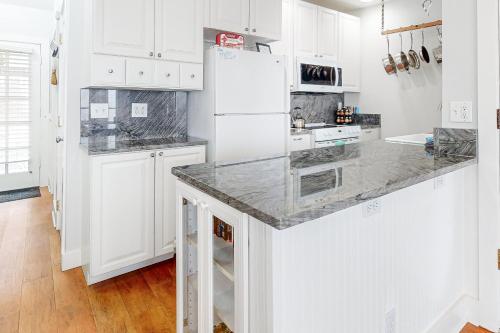 a kitchen with white cabinets and a marble counter top at Berni's Ocean View Castle - an Oceanside Legend in Oceanside
