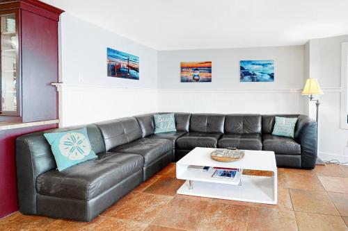 a living room with a leather couch and a coffee table at Berni's Ocean View Castle - an Oceanside Legend in Oceanside