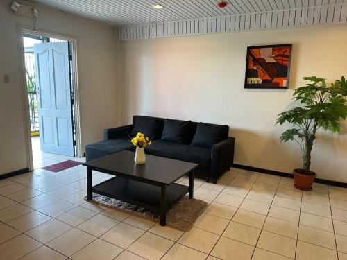 ein Wohnzimmer mit einem Sofa und einem Couchtisch in der Unterkunft Southside Apartments in Paramaribo