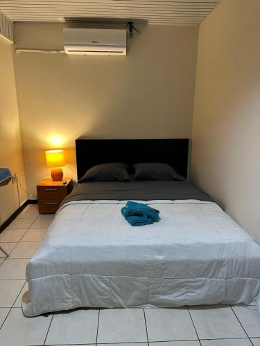 a bedroom with a large bed with a blue bag on it at Southside Apartments in Paramaribo