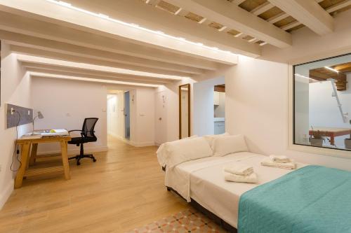 a bedroom with a bed and a desk and a chair at Estudio Amor BRUJO by Cadiz4Rentals in Cádiz