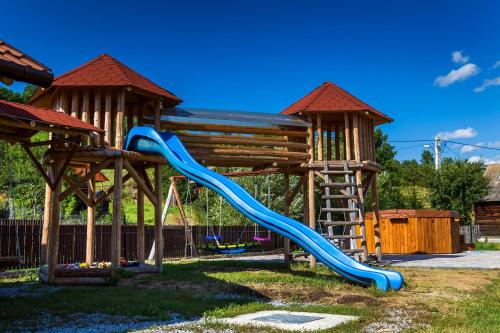 a playground with a blue slide in a park at Erőss Kulcsosház in Lăzarea