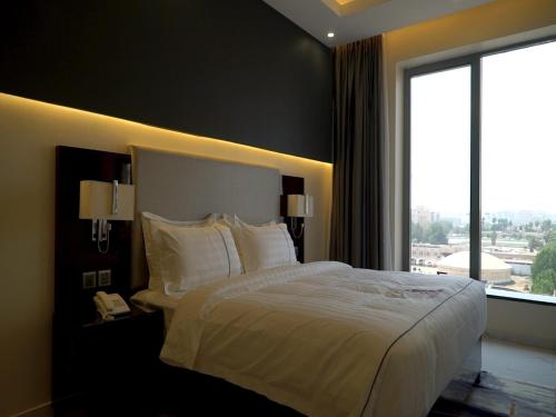 Habitación de hotel con cama grande y ventana en Violet Rose ApartHotel, en Yeda