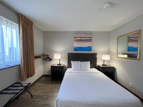 a bedroom with a large bed and two lamps at Days Inn by Wyndham Orange Park/Jacksonville in Orange Park