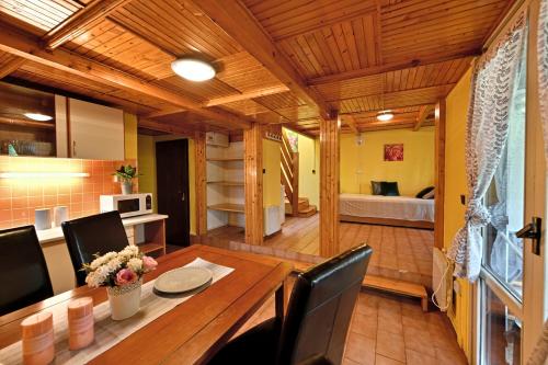 uma cozinha e sala de jantar com uma mesa de madeira e cadeiras em Apartmány Orlík 2 em Klučenice