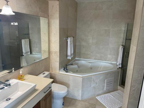 ein Badezimmer mit einer Badewanne, einem WC und einem Waschbecken in der Unterkunft 17E Beautiful 2-Bedroom Ocean View Apartment in Playa Bonita Village