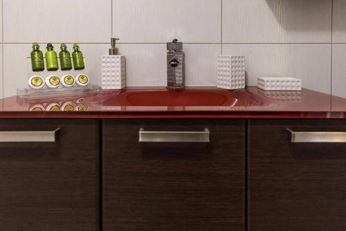 a bathroom counter with a sink with bottles on it at Ionias Apartment in Heraklion in Heraklio