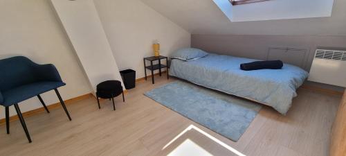 a small bedroom with a bed and a chair at Un Havre de Paix in Villepinte