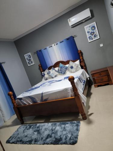 a bedroom with a bed with a blue canopy at victory Luxury Suites in Montego Bay