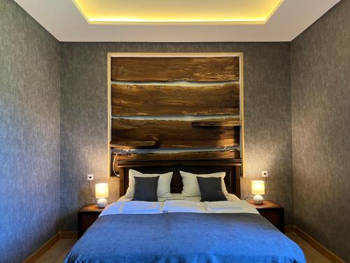 a bedroom with a large bed with a blue blanket at Hotel Nordmann,Racha in Ambrolauri