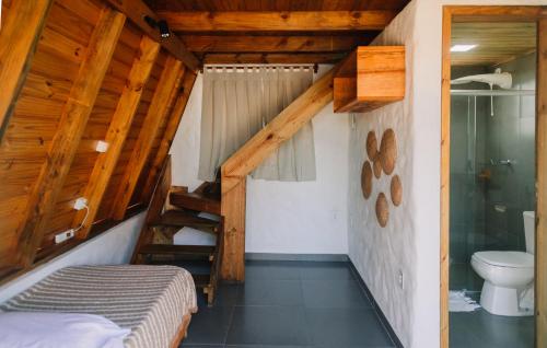 a bedroom with a bed and a shower and a toilet at Vila Pahú - Caraíva in Caraíva