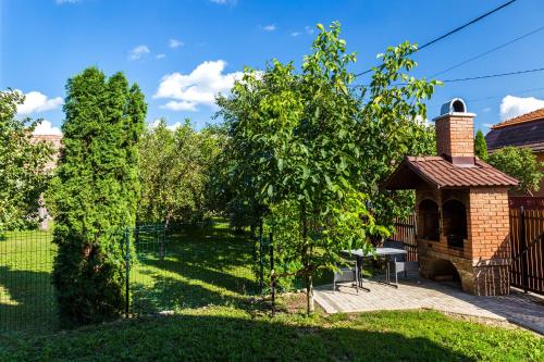a garden with a gazebo and trees at Erőss Kulcsosház in Lăzarea