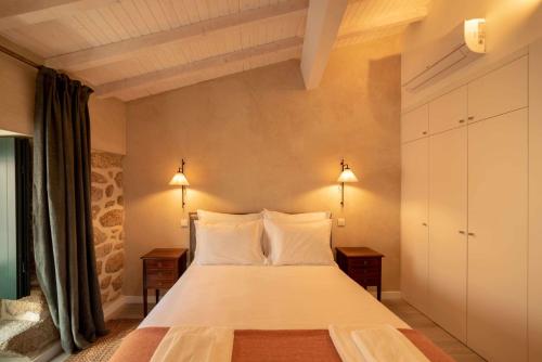una camera da letto con un letto grande con due comodini di Casa Prosa - Santar a Santar