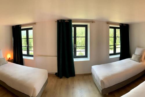 two beds in a room with two windows at Le Perchoir - Gîte 7 personnes / pleine nature / Altitude : 830 m in Ban-sur-Meurthe-Clefcy