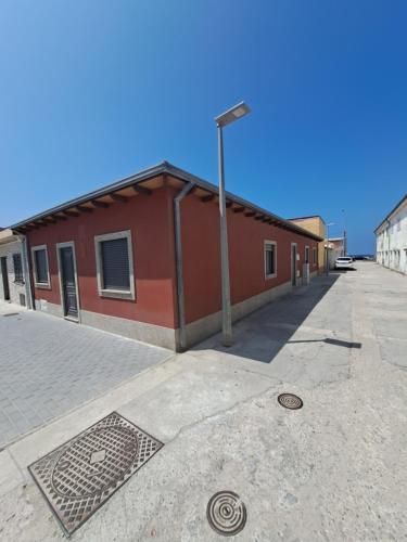 ein rotes Gebäude mit Straßenbeleuchtung daneben. in der Unterkunft Beach House in Espinho