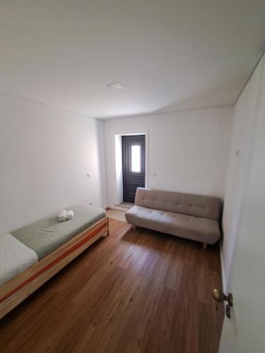 una camera da letto con un letto e un divano in una stanza di Beach House a Espinho