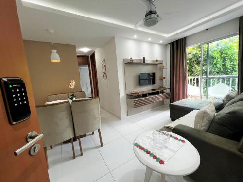 a living room with a couch and a table at Lua Nova - Vog Acqua Apt na Praia dos Milionários in Ilhéus