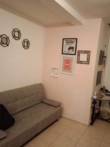 un soggiorno con divano e immagini appese al muro di Alojamientos holgo a Ciudad Juárez