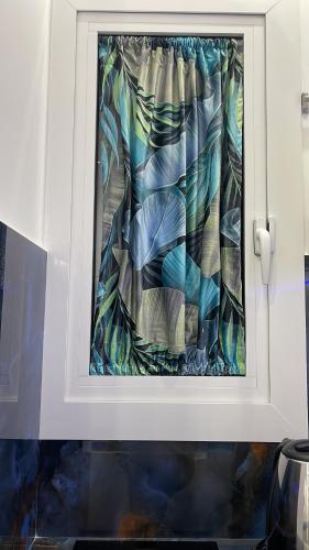 a window in a white cabinet with a curtain at Alex mary home in Naples