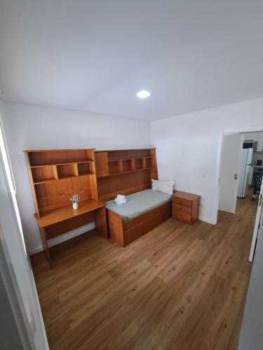 een kleine kamer met een bed en een bureau bij Beach House 2 in Espinho