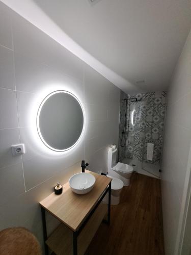 een badkamer met een wastafel, een spiegel en een toilet bij Beach House 2 in Espinho