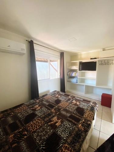 a bedroom with a bed and a microwave at Sobrados Molhes in Passo de Torres