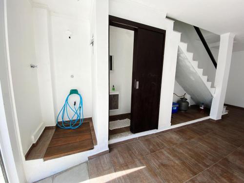 a hallway with a black door and stairs with a blue hose at Sobrados Molhes in Passo de Torres