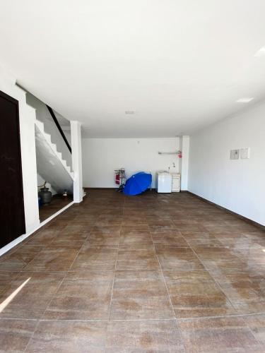 an empty room with a tile floor and a staircase at Sobrados Molhes in Passo de Torres