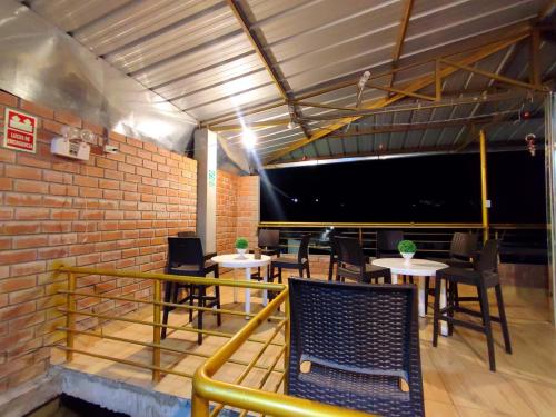 ティンゴ・マリアにあるGarrison Alojamiento , selva y Turismo y Comidaのテーブルと椅子、大画面のレストランを併設しています。