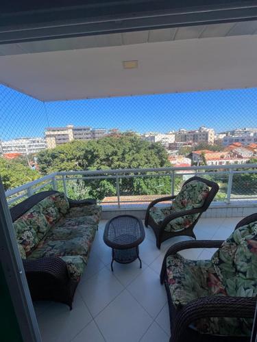 a balcony with couches and a view of a city at Apto acolhedor na Passagem in Cabo Frio