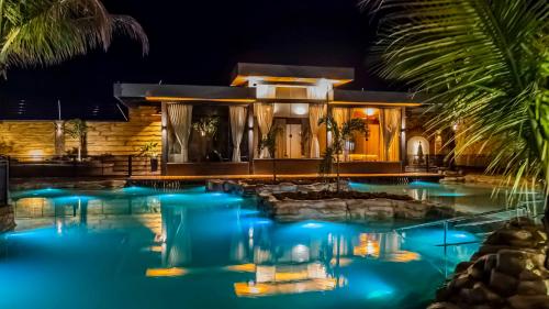 a house with a swimming pool at night at Carpe Diem Eco Resort & SPA in Olímpia