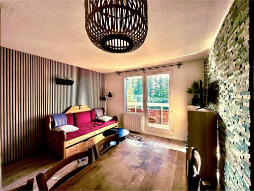 - un salon avec un canapé et une fenêtre dans l'établissement APPARTEMENT 310 ECRIN D'HUEZ, à L'Alpe-d'Huez
