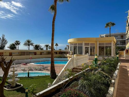 ein Resort mit einem Pool, Palmen und einem Gebäude in der Unterkunft Apartamento cerca de la playa in Maspalomas