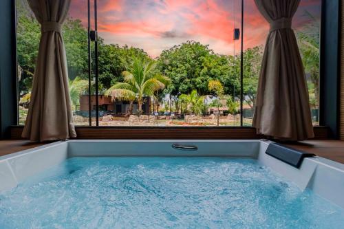 a bath tub with a view of a resort at Carpe Diem Eco Resort Olímpia in Olímpia