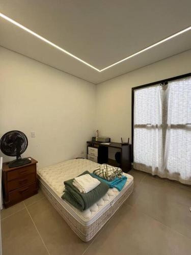 Cette chambre comprend un lit et un bureau. dans l'établissement Casa com piscina e área gourmet com churrasqueira integrada, à Maringá