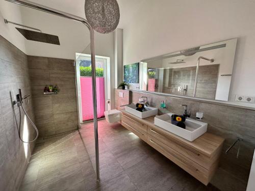 ein Bad mit 2 Waschbecken und einer Dusche in der Unterkunft Idylisches Ferienhaus in Edewecht