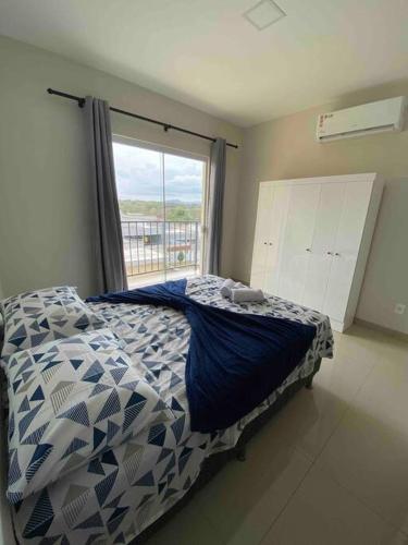 a bedroom with a bed with a blue and white comforter at Flat Delior 07 - Parada do Jalapão, rodoviária, faculdades e Aeroporto in Palmas