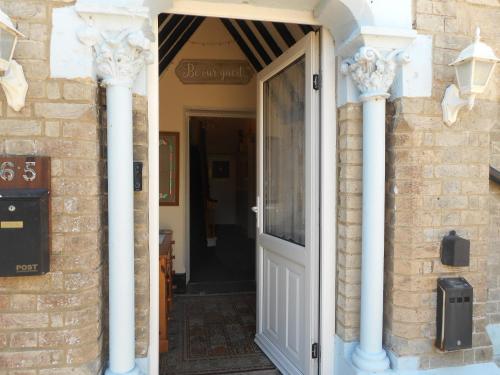 a door to a house with white columns at The George B&B in Weymouth