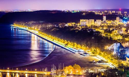 a city with a bridge over a river at night at Mieszkanie w samym sercu Gdyni, 3 minuty od plaży. in Gdynia