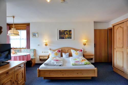 a bedroom with a bed with two pillows and a television at Haus Bavaria in Reit im Winkl