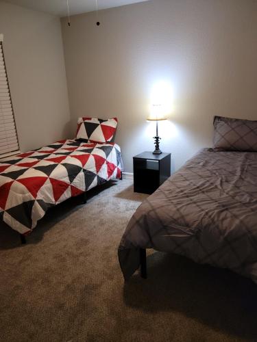 um quarto com duas camas e um candeeiro sobre uma mesa em Fresh CrashPads em Houston