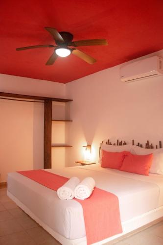 a bedroom with a bed with a ceiling fan at Hotelito El Cuyo in El Cuyo