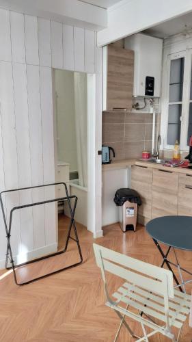 un salon avec une table et une cuisine dans l'établissement STUDIO RUE GAUTHEY PARIS 17, à Paris