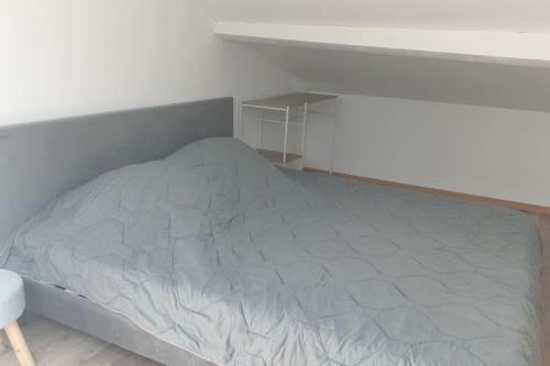 un lit dans une chambre blanche avec un cadre de lit dans l'établissement Appartement neuf 100m² clim haut villa, à Ollioules