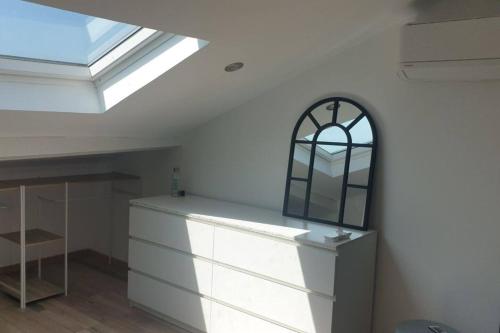 Cette chambre dispose d'une fenêtre et d'une commode avec un miroir. dans l'établissement Appartement neuf 100m² clim haut villa, à Ollioules