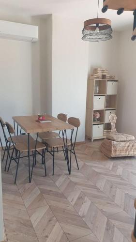 une salle à manger avec une table et des chaises en bois dans l'établissement Appartement neuf 100m² clim haut villa, à Ollioules