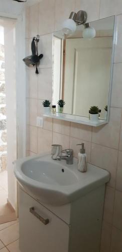 a bathroom with a white sink and a mirror at Vilaeti Dimitra in Agios Konstantinos