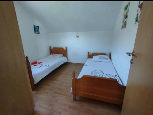 a room with two beds in a room with a door at Kuća za odmor Jeličić 